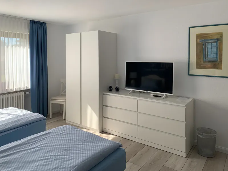 Schlafzimmer mit Kleiderschrank und Fernseher