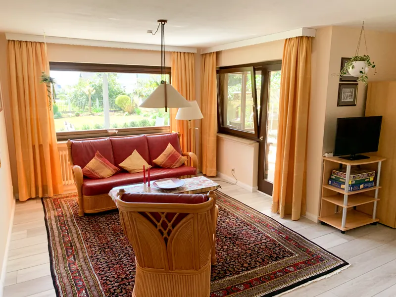 Heller Wohnbereich der Ferienwohnung mit Blick in den Garten